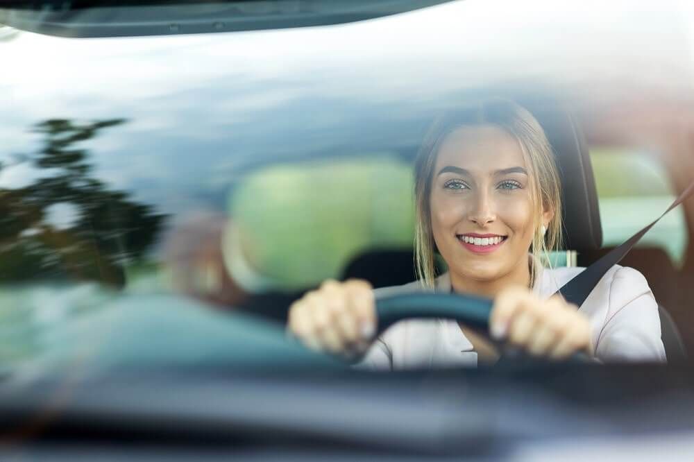 Junge Frau hinter Autolenkrad