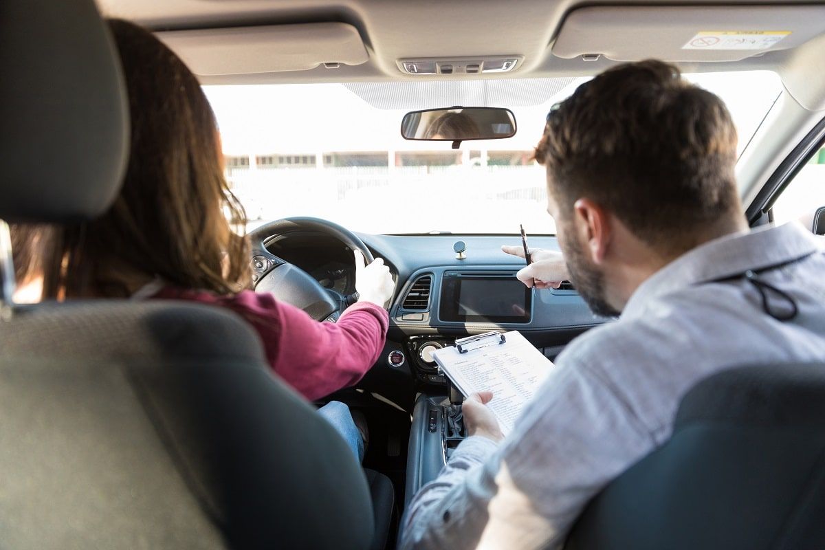 Fahrlehrer mit Fahrschülerin im Auto